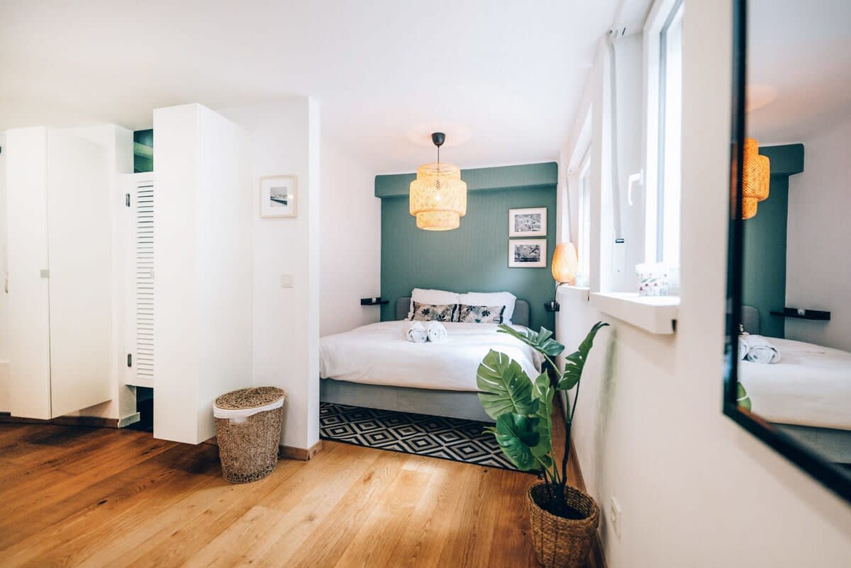 Inviting bedroom with modern decor and large windows, offering a bright and relaxing atmosphere for a perfect night's rest.