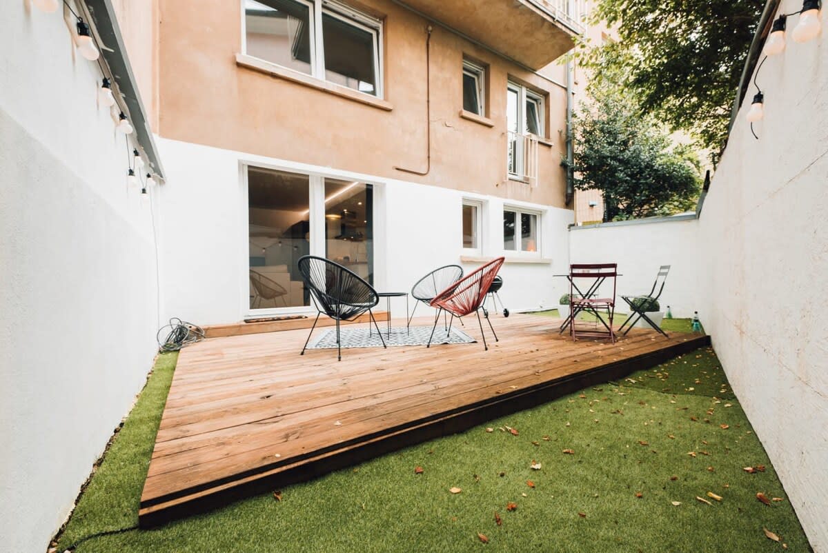 Spacious backyard with a wooden deck and cozy seating, ideal for outdoor dining and relaxation in a private setting.