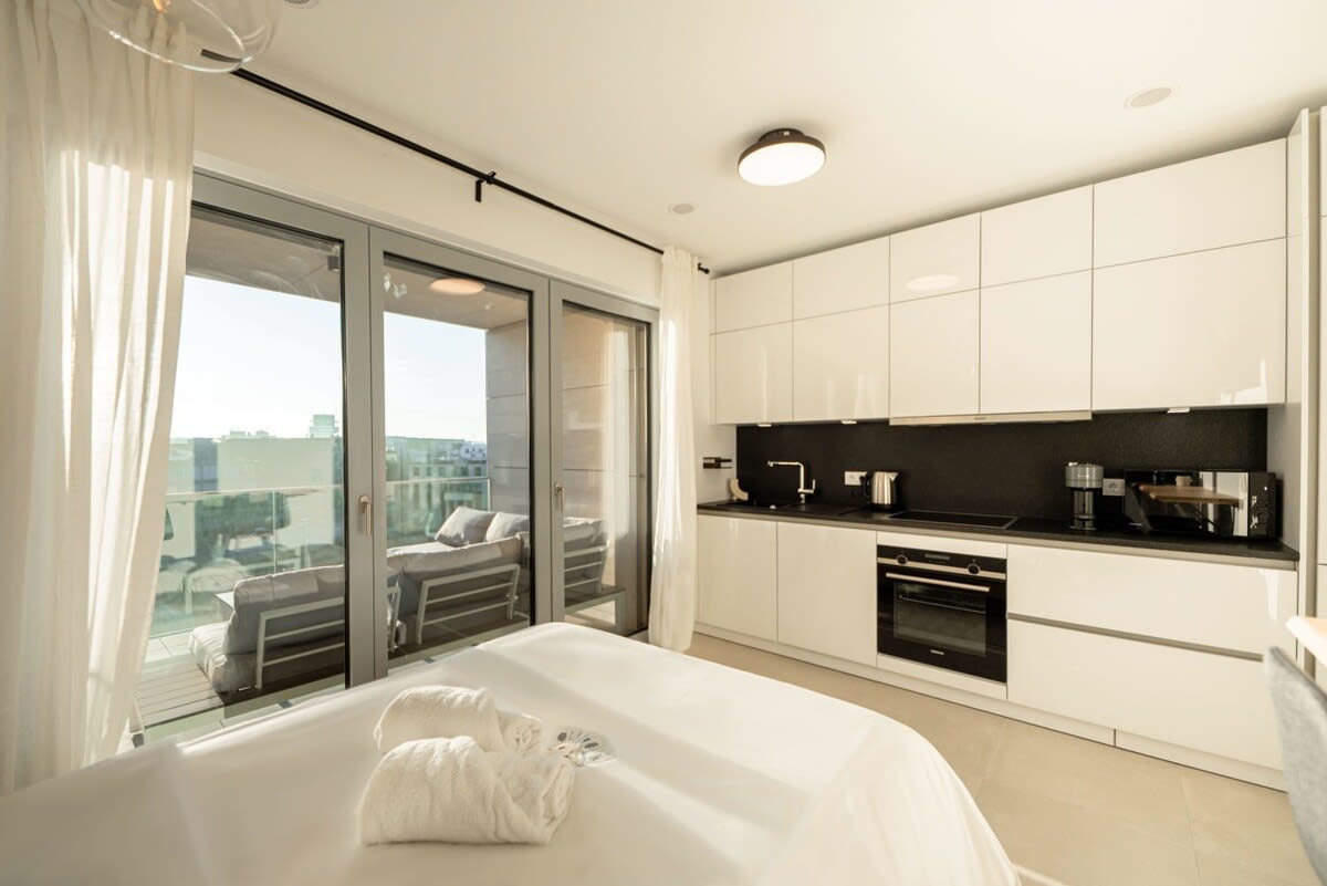 Serene bedroom with direct access to a private balcony, blurring the lines between indoors and out.