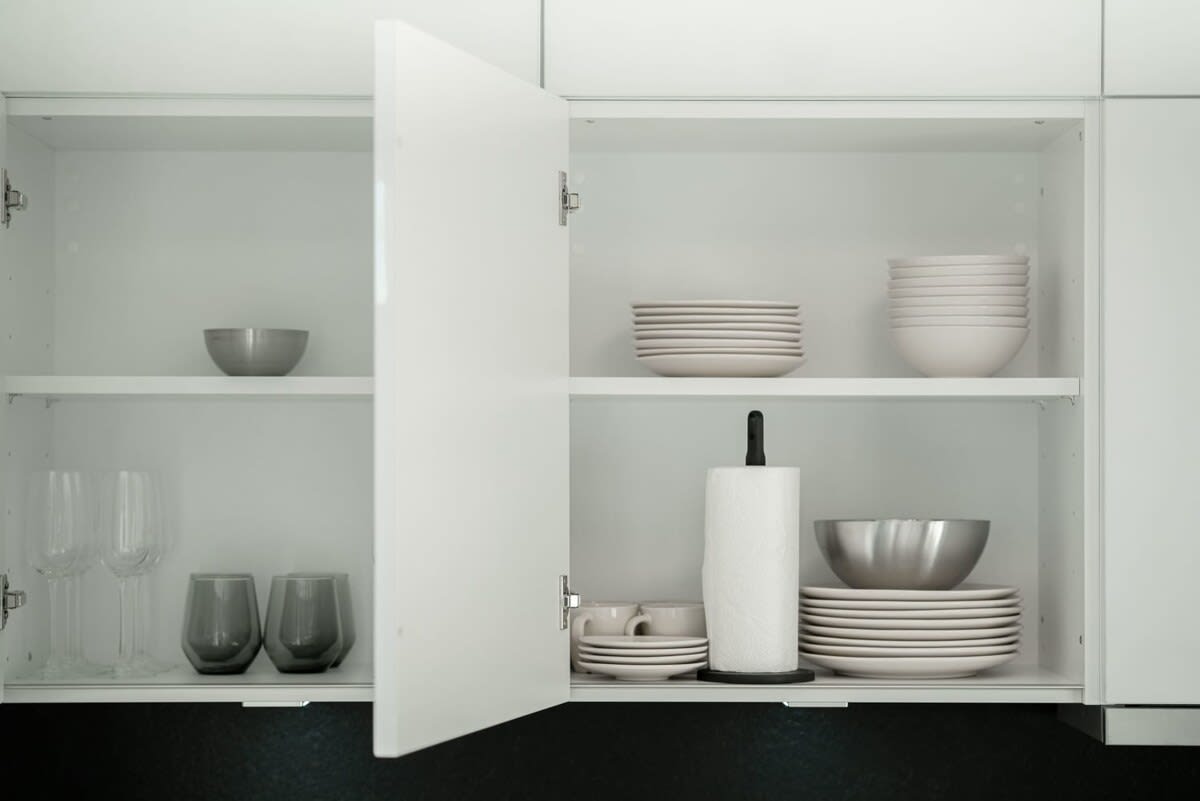Sleek minimalist kitchen cabinets stocked with essentials, awaiting your culinary adventures.