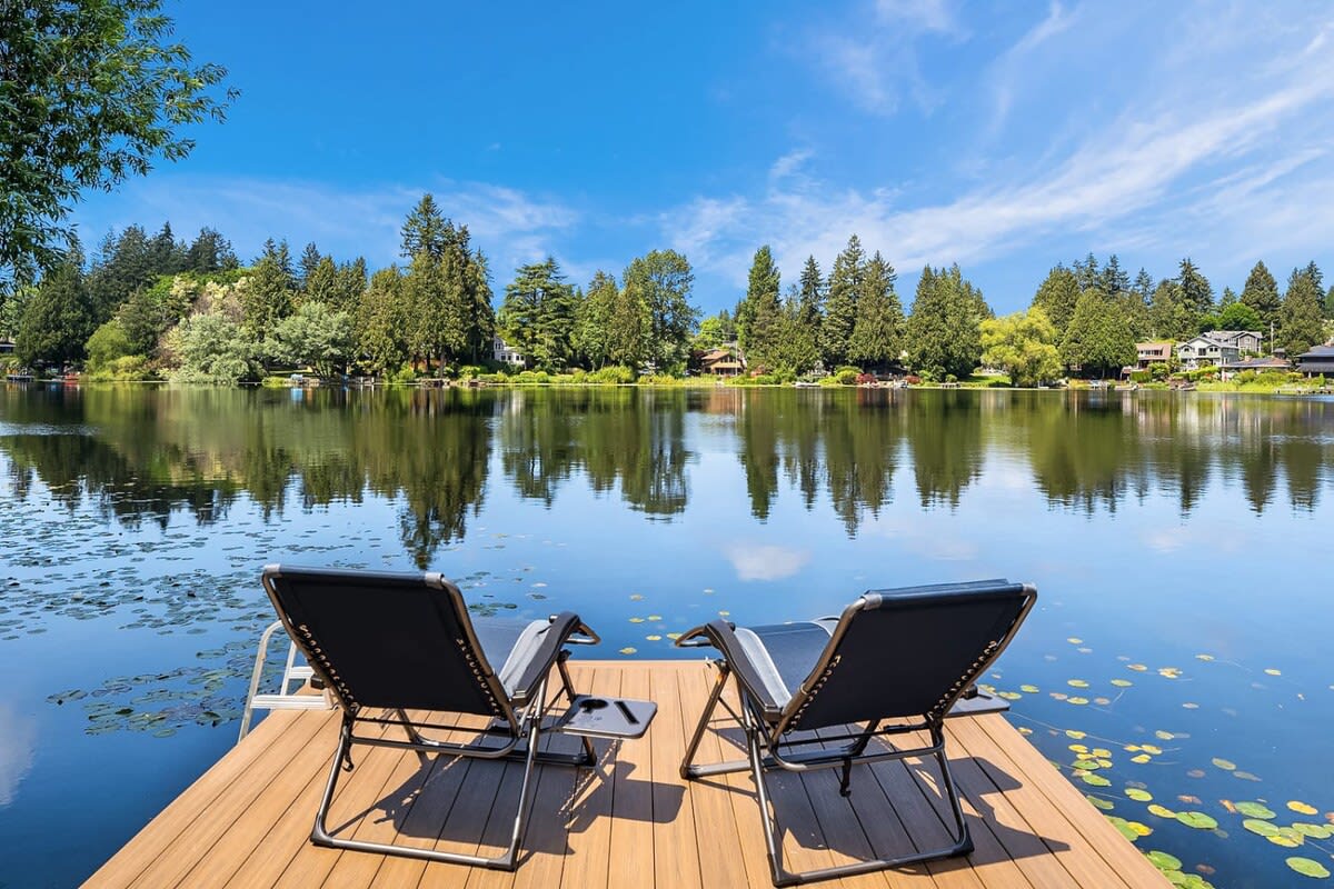 2 chairs on a deck on lake side