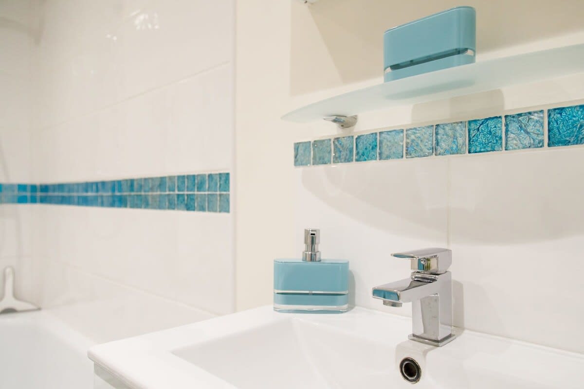 The family bathroom has a WC, sink and a bath with overhead shower.