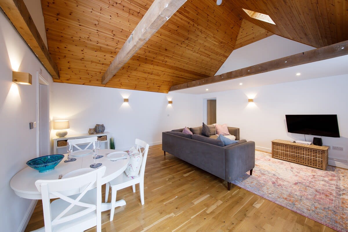 Spacious open-plan living and dining area, with comfy sofa, wifi and TV.