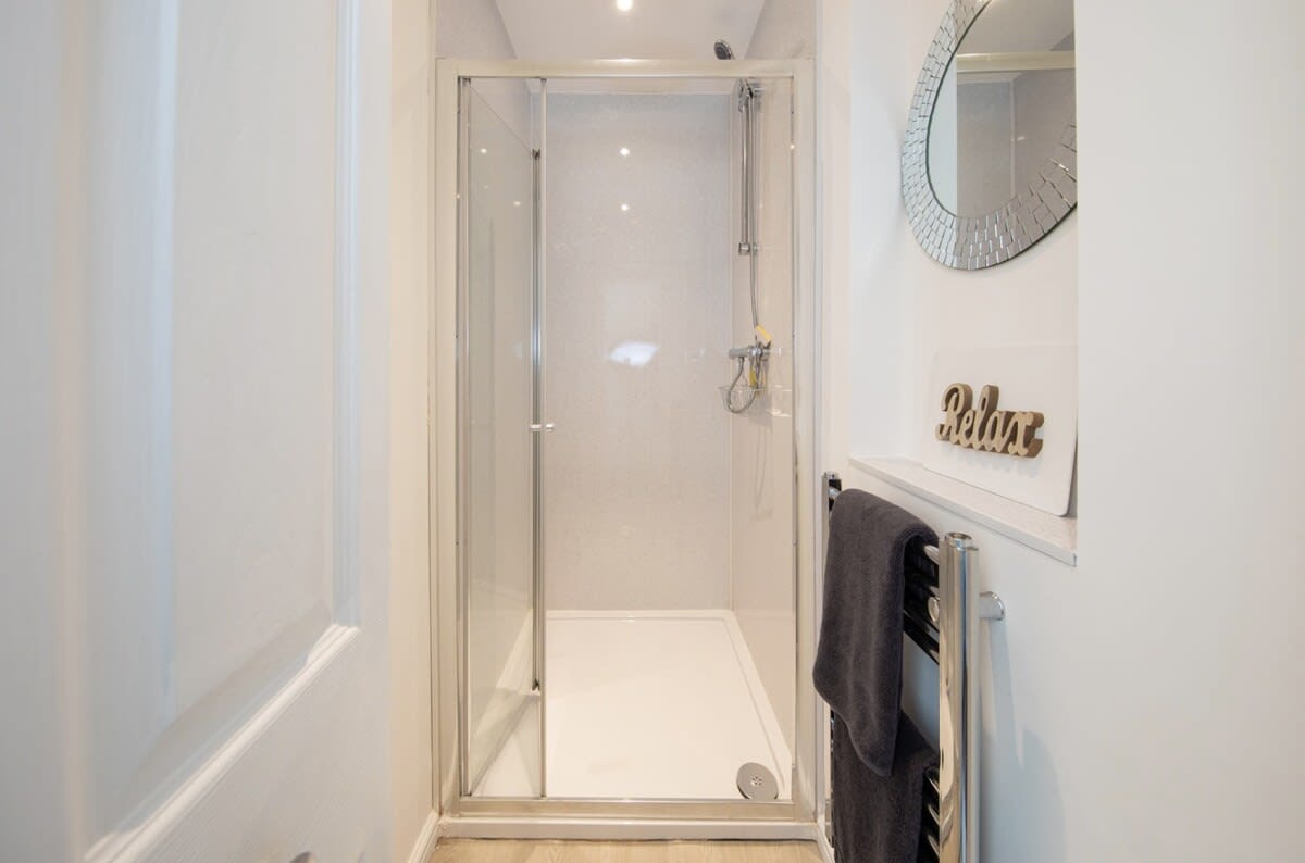 The sparkling shower room with a heated towel rail