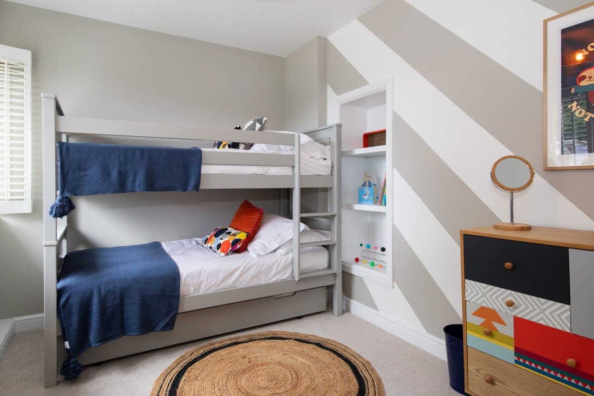 The children’s room includes a bunk plus trundle sleeping 3. A chest of drawers and toys.