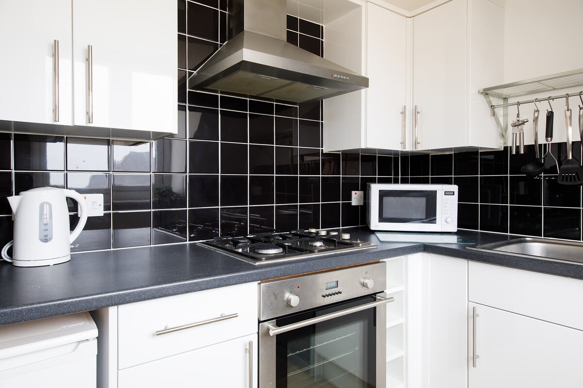 Fully-equipped kitchen with microwave, oven, gas hob, toaster, kettle and dishwasher.