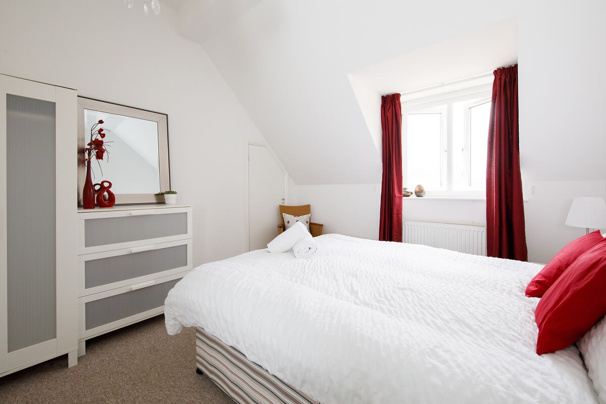 Comfy king-sized bed in the light and bright bedroom.