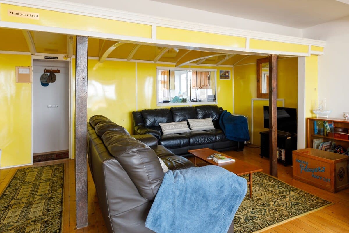 The vibrant lounge is built around a train carriage, giving the home a unique and cosy feel.