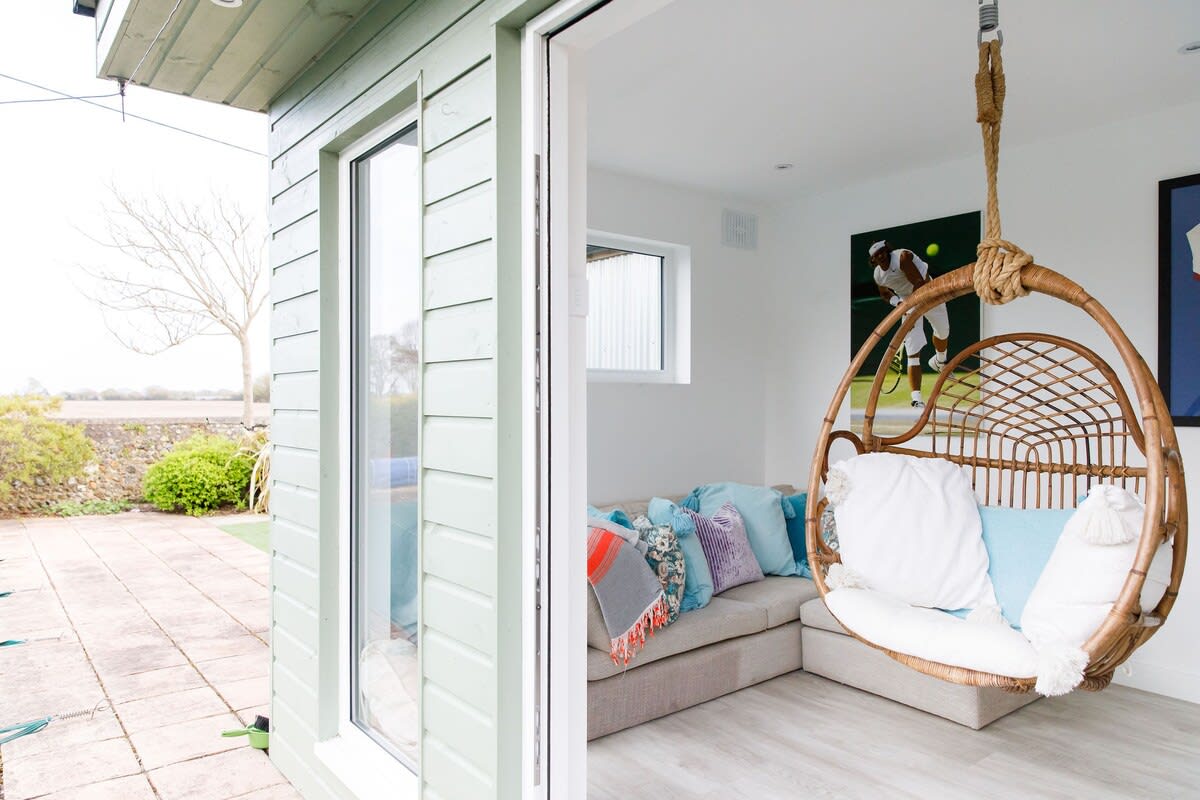 The separate home gym has a comfy egg seat and corner sofa.