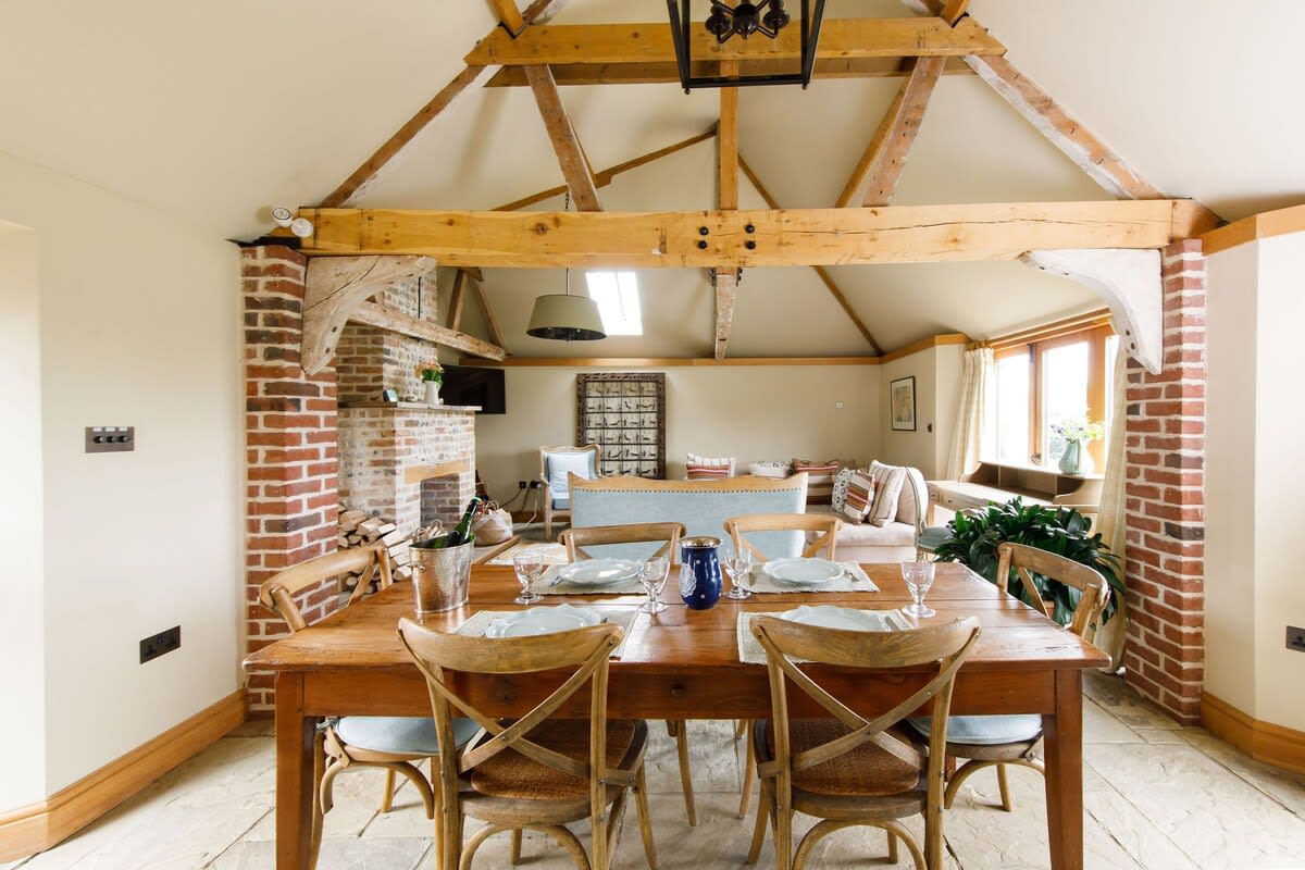 Reclaimed beams and exposed brick frames the dining and living space.