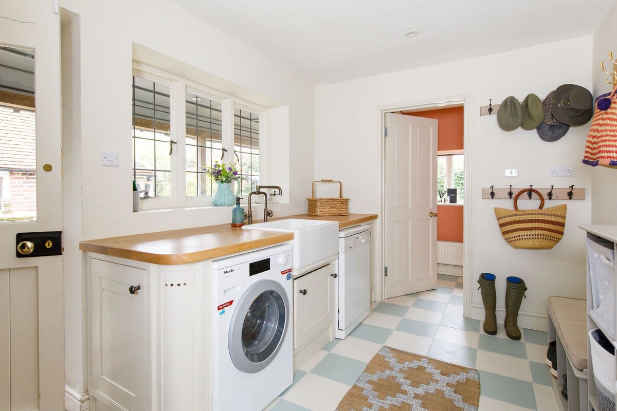 The functional utility room with washer/dryer, sink and space for coats and boots.