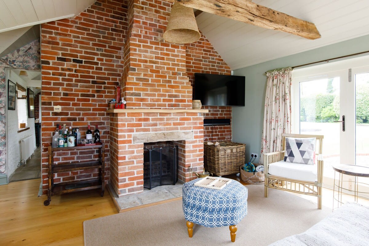 The lounge has exposed brick, original fireplace and wooden beams, giving a rustic but cosy feel.