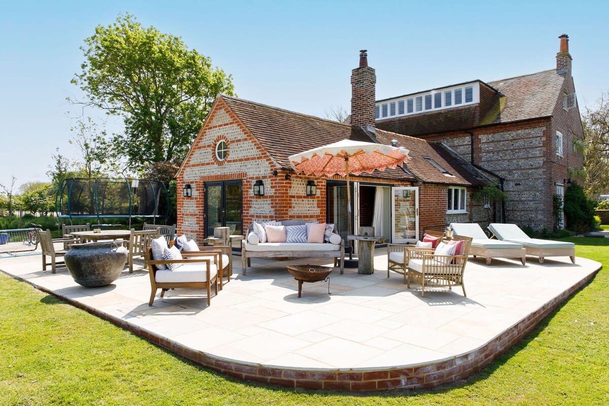 The rear of the main house has a large wraparound patio with seating, sun loungers, fire pit and pizza oven.