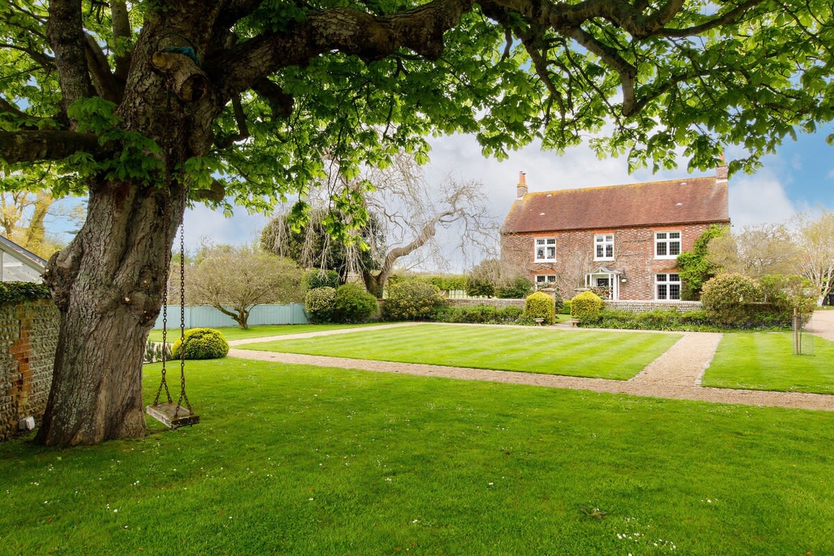 The home is surrounded by extensive grounds and mature gardens.