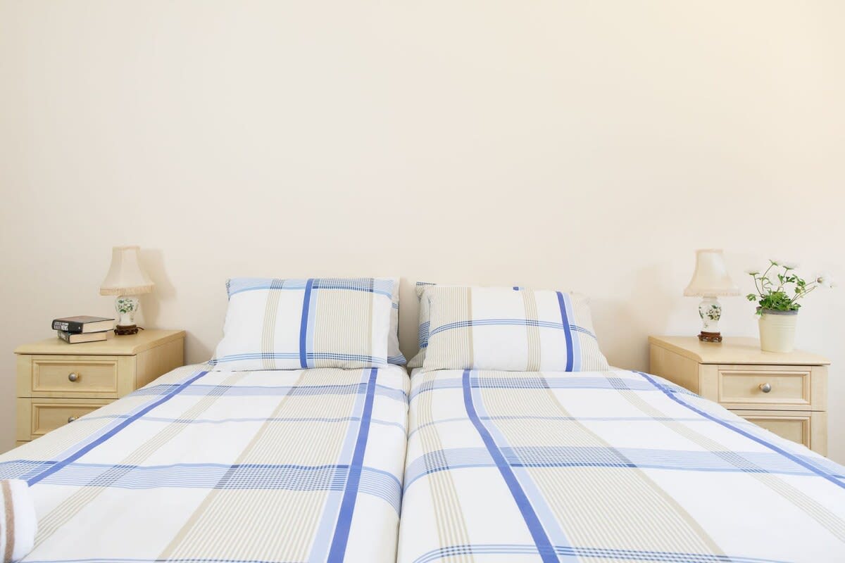 Bedside tables and reading lamps are found in both bedrooms.