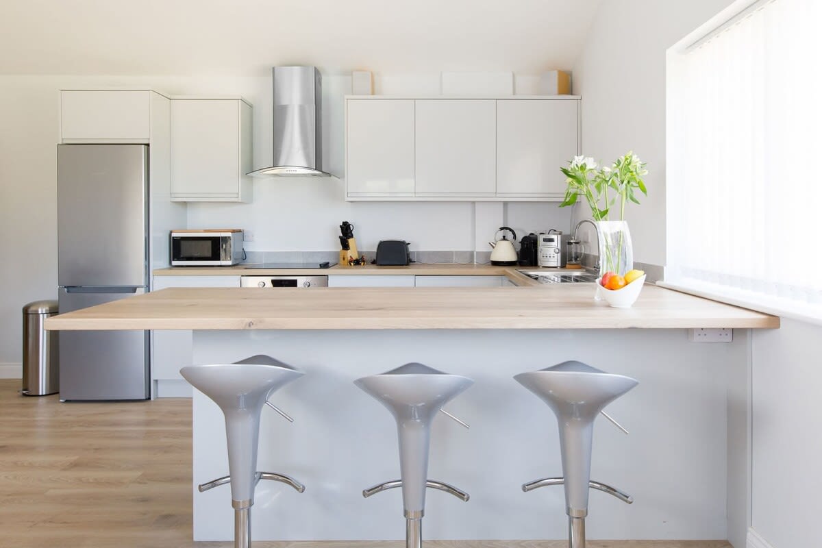 There is a breakfast bar with three comfy stools. Perfect for a morning coffee or evening drink.