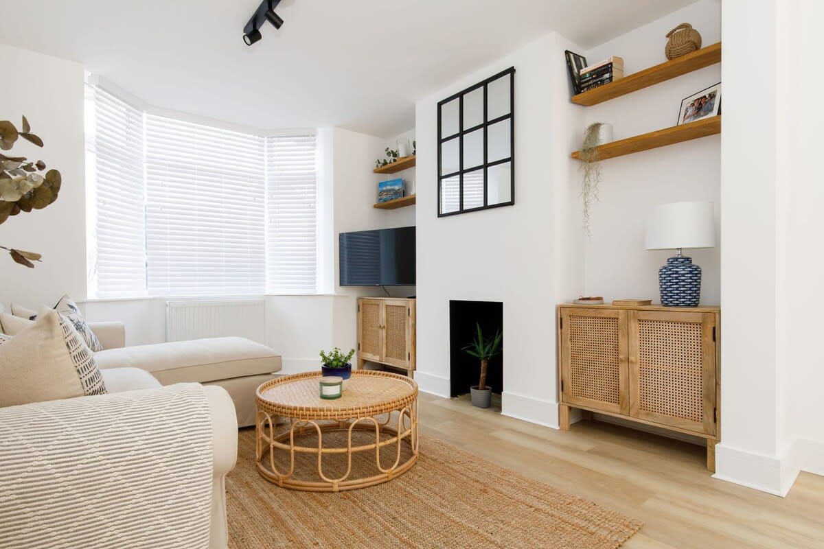 The living room has a neutral décor with hints of rattan furniture to unwind in stylish surroundings.