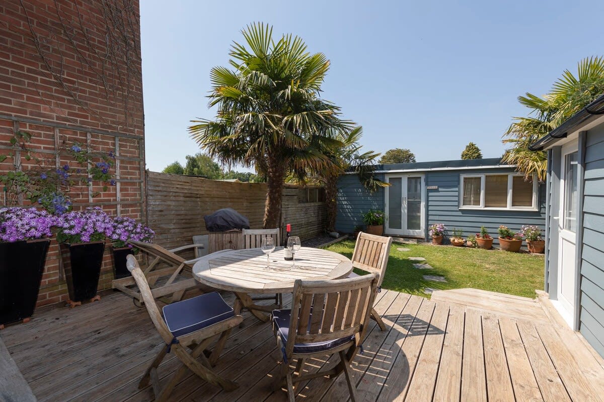 The decking in the garden sits the garden dining furniture.