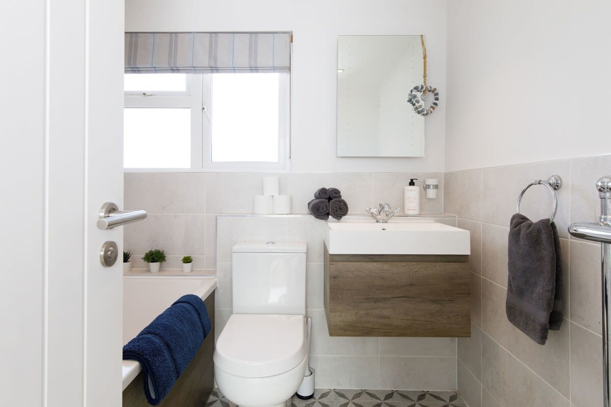 The home has a spacious and modern family bathroom stocked with fresh towels.