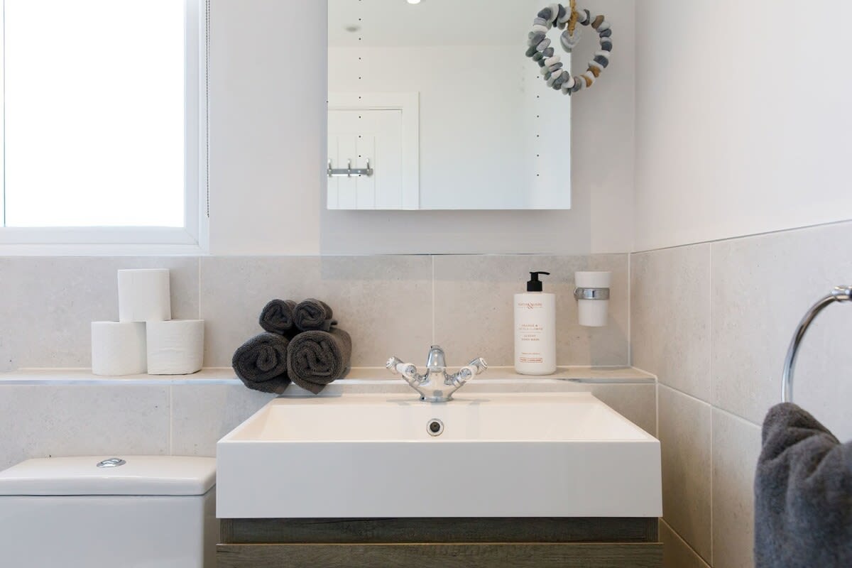 The sink has an overhead vanity mirror.