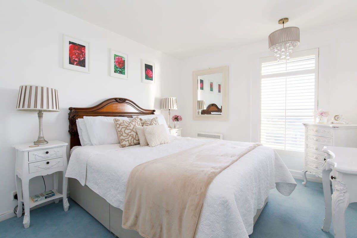 The second room features a comfortable double bed, reading lamps and vanity.