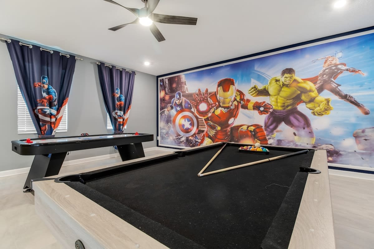 Unleash your inner hero in this vibrant game room with pool and air hockey tables, perfect for family fun!