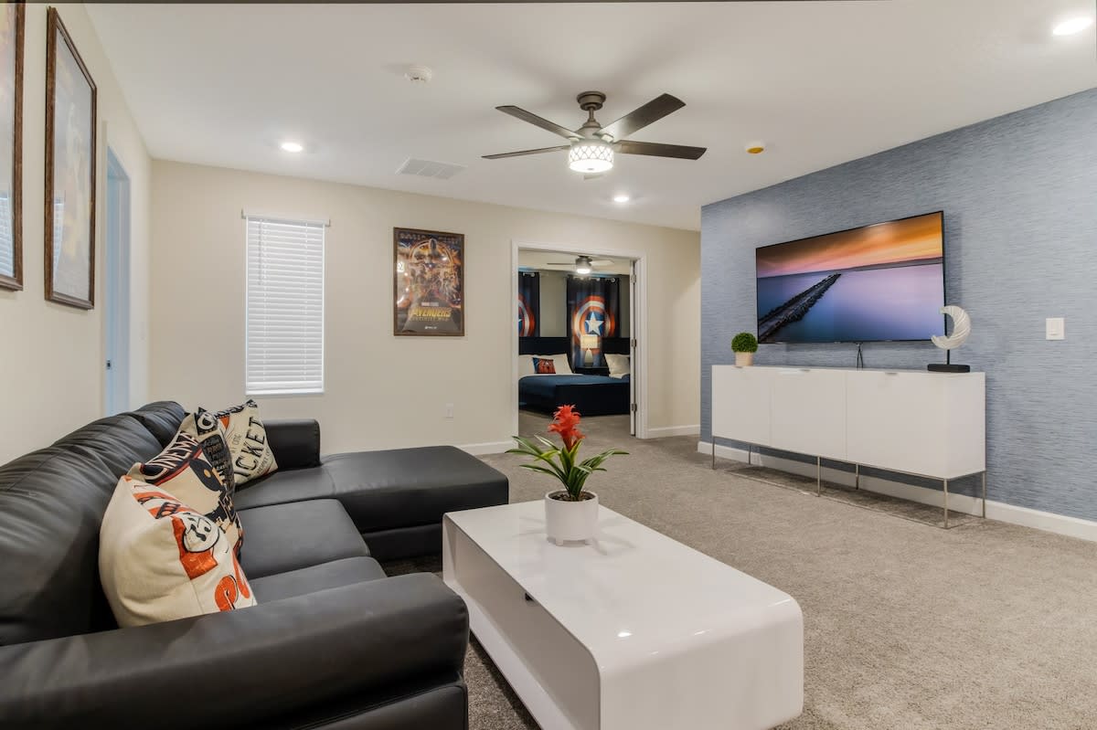 Relax in style with a spacious living room featuring a sleek leather sofa, vibrant decor, and a large flat-screen TV for ultimate comfort.