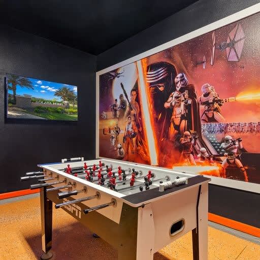 Unleash your inner Jedi in this Star Wars-themed game room, complete with a foosball table and entertainment setup.