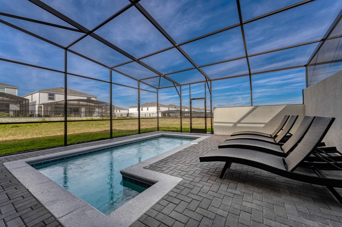 Unwind by your private screened pool with stylish loungers and enjoy tranquil views in a serene setting.