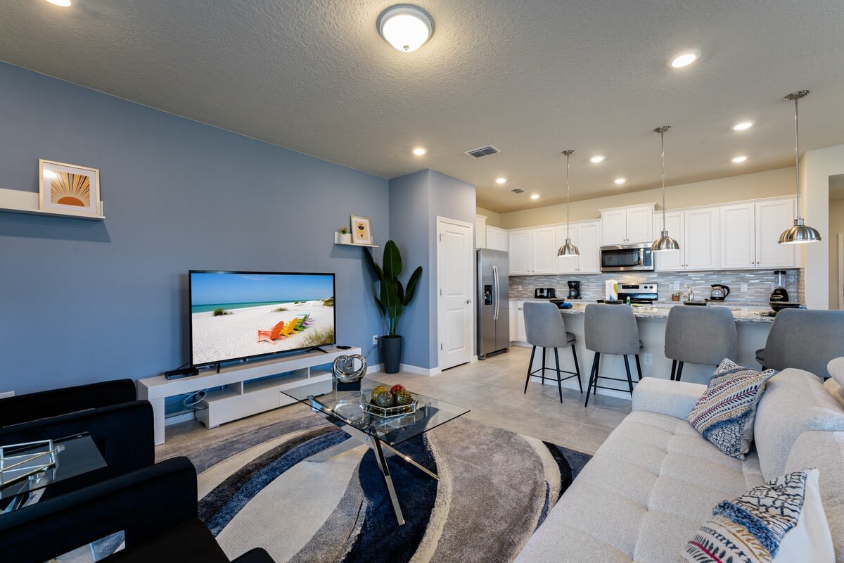 Modern living room with sleek design, comfy seating, and open kitchen perfect for entertaining.