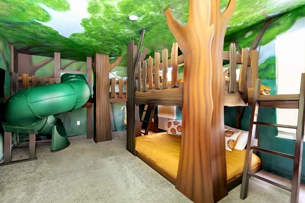 Experience the magic of a treehouse-themed room with bunk beds and a slide, perfect for family fun and adventure.