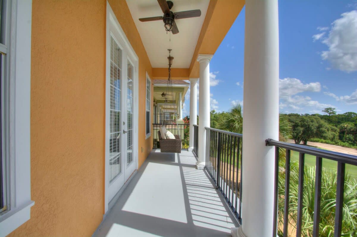 Relax on the charming balcony with a hanging chair, enjoying serene views of lush greenery and a peaceful atmosphere.