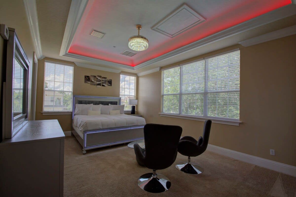 Experience luxury in this stylish bedroom featuring ambient lighting, a plush king-sized bed, and modern decor for your perfect getaway.
