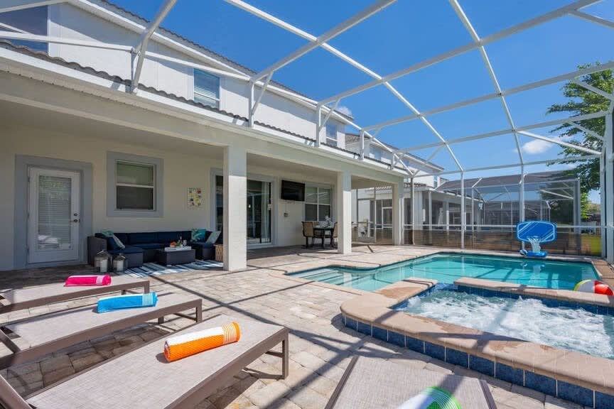 Relax in your private screened pool and hot tub, complete with sun loungers and a cozy seating area for the ultimate retreat.