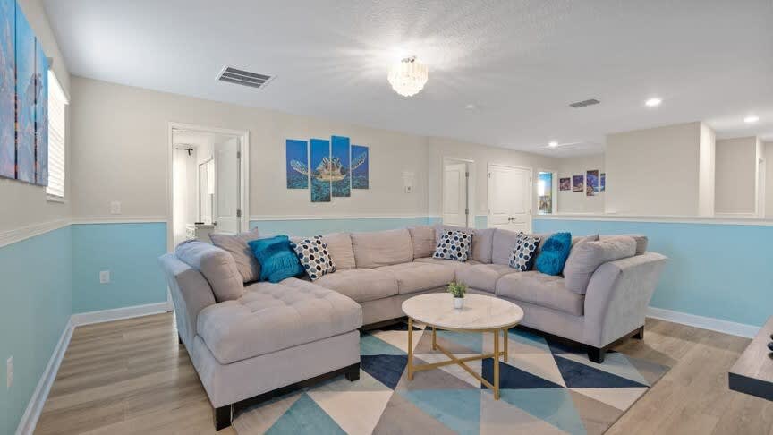 Relax in this inviting living room with a plush sectional, vibrant decor, and cozy ambiance, perfect for family gatherings.