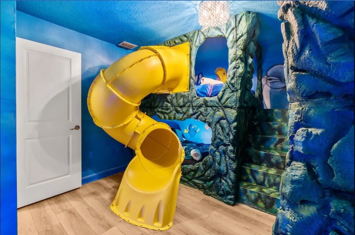 Dive into fun with this ocean-themed room featuring a thrilling slide and vibrant marine decor, perfect for unforgettable family adventures.