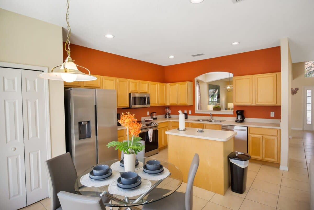 Bright and modern kitchen with stainless steel appliances and a cozy dining area, perfect for family meals.