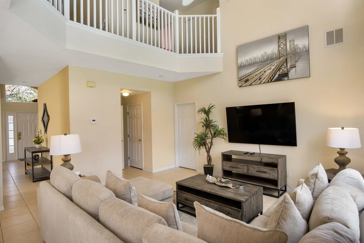 Relax in this spacious living room with a cozy sectional sofa and modern decor, perfect for unwinding after a day of exploring.