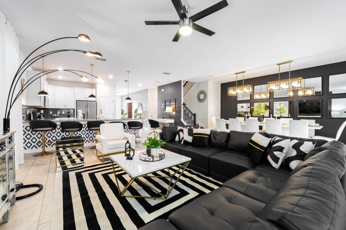 Stunning open-plan living area with chic black and white decor, perfect for entertaining and relaxation. Enjoy ample seating and stylish design.
