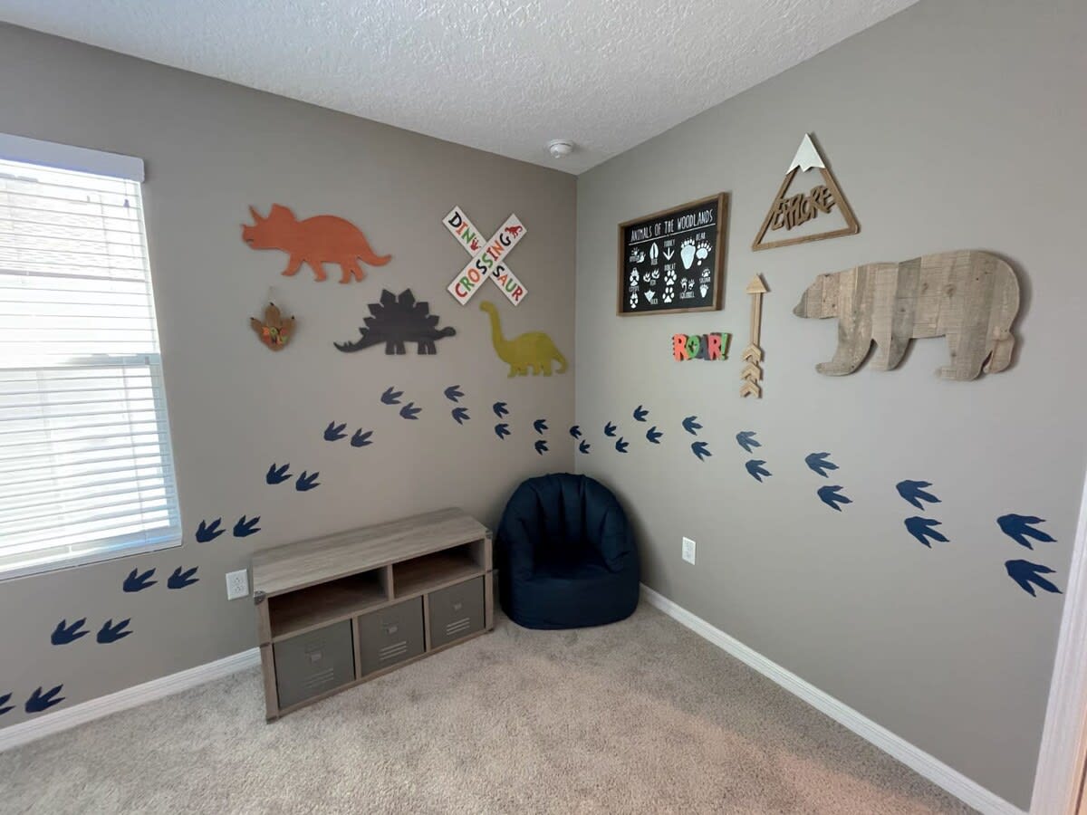Delight your kids with a dino-themed room featuring playful decor and a cozy bean bag chair—perfect for their prehistoric adventures!