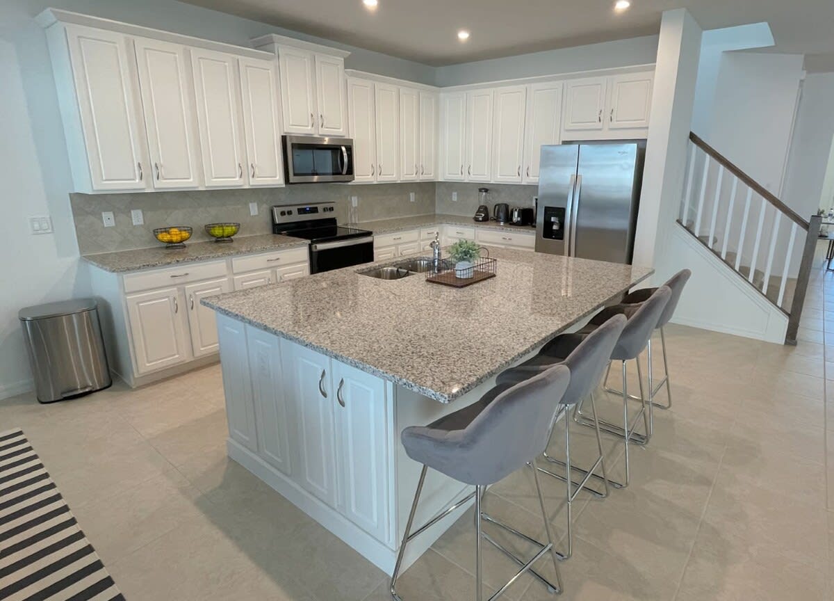 Elegant kitchen with granite island and seating, perfect for family meals and entertaining.