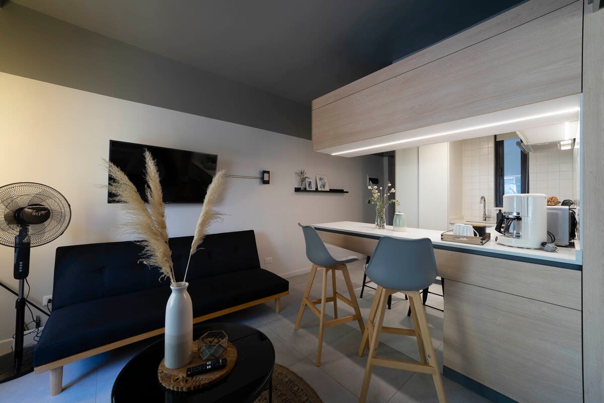 Cozy studio living area with modern amenities and a stylish breakfast bar, perfect for a relaxing stay in the heart of the city.
