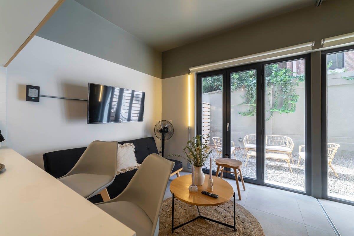 Cozy living area with modern amenities and access to a charming outdoor patio, perfect for relaxation.