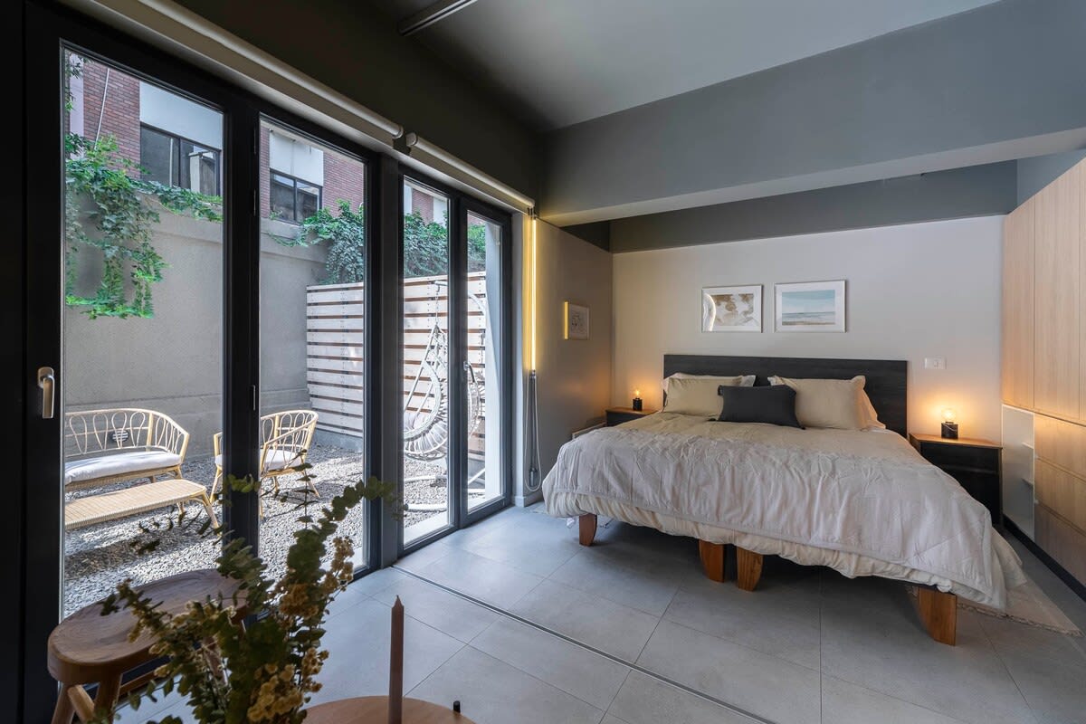Relax in this stylish bedroom with private patio access, perfect for unwinding after a day in the city.