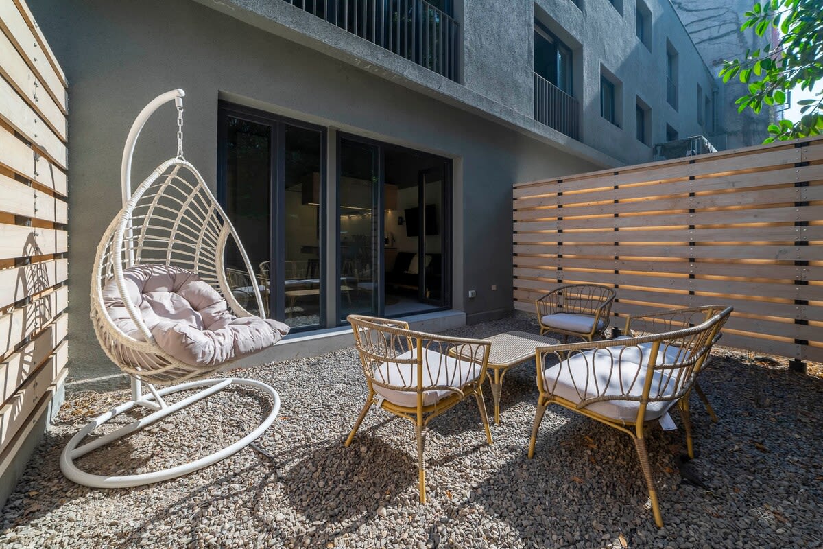 Relax in your private patio oasis with cozy seating and a hanging chair, perfect for unwinding in the Chilean sun.