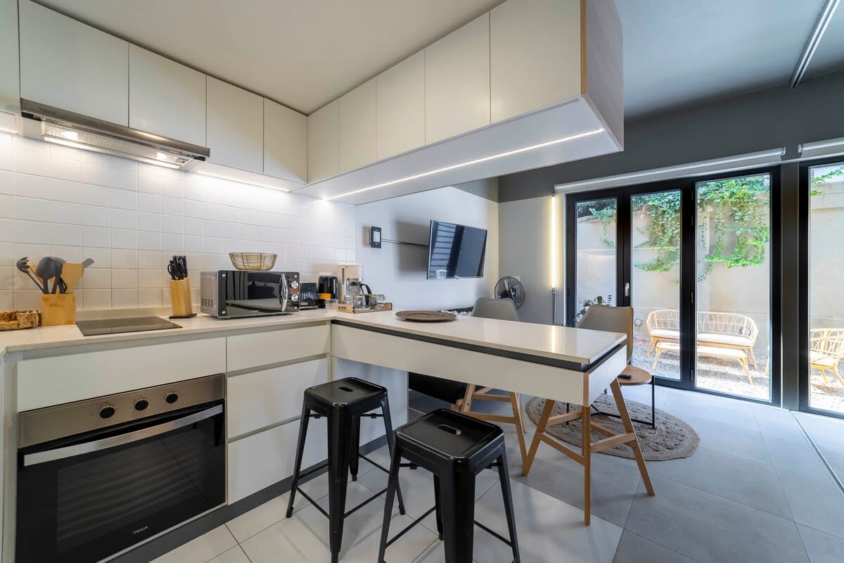 Sleek and modern kitchen with ample natural light and direct access to a charming outdoor area.