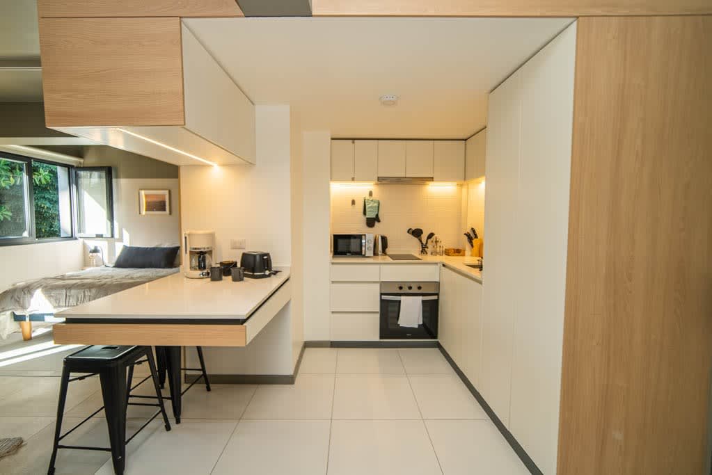 Sleek and modern kitchen with all essentials, perfect for cooking your favorite meals during your stay. Cozy breakfast bar included.