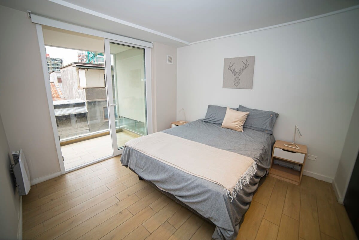 Relax in this cozy bedroom with direct balcony access, perfect for enjoying the city views.