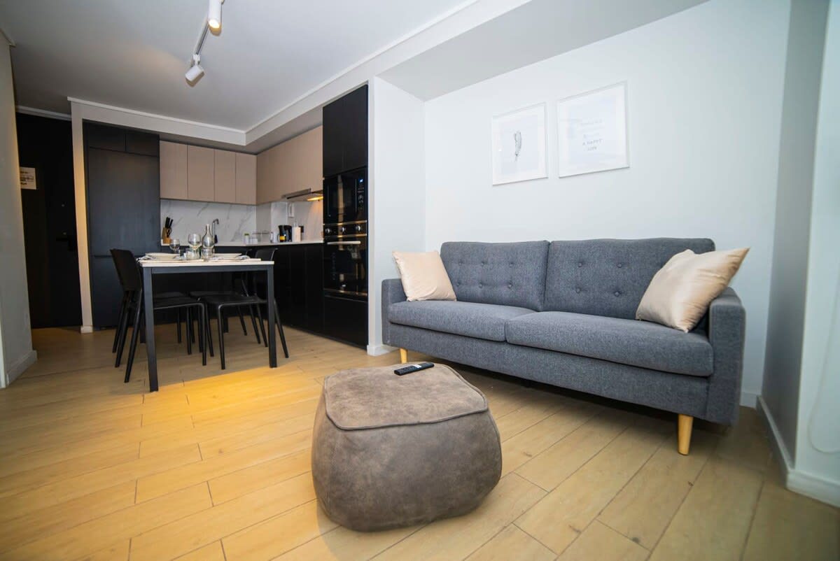 Cozy and modern living space with a sleek kitchen and comfortable seating, perfect for a relaxing stay.