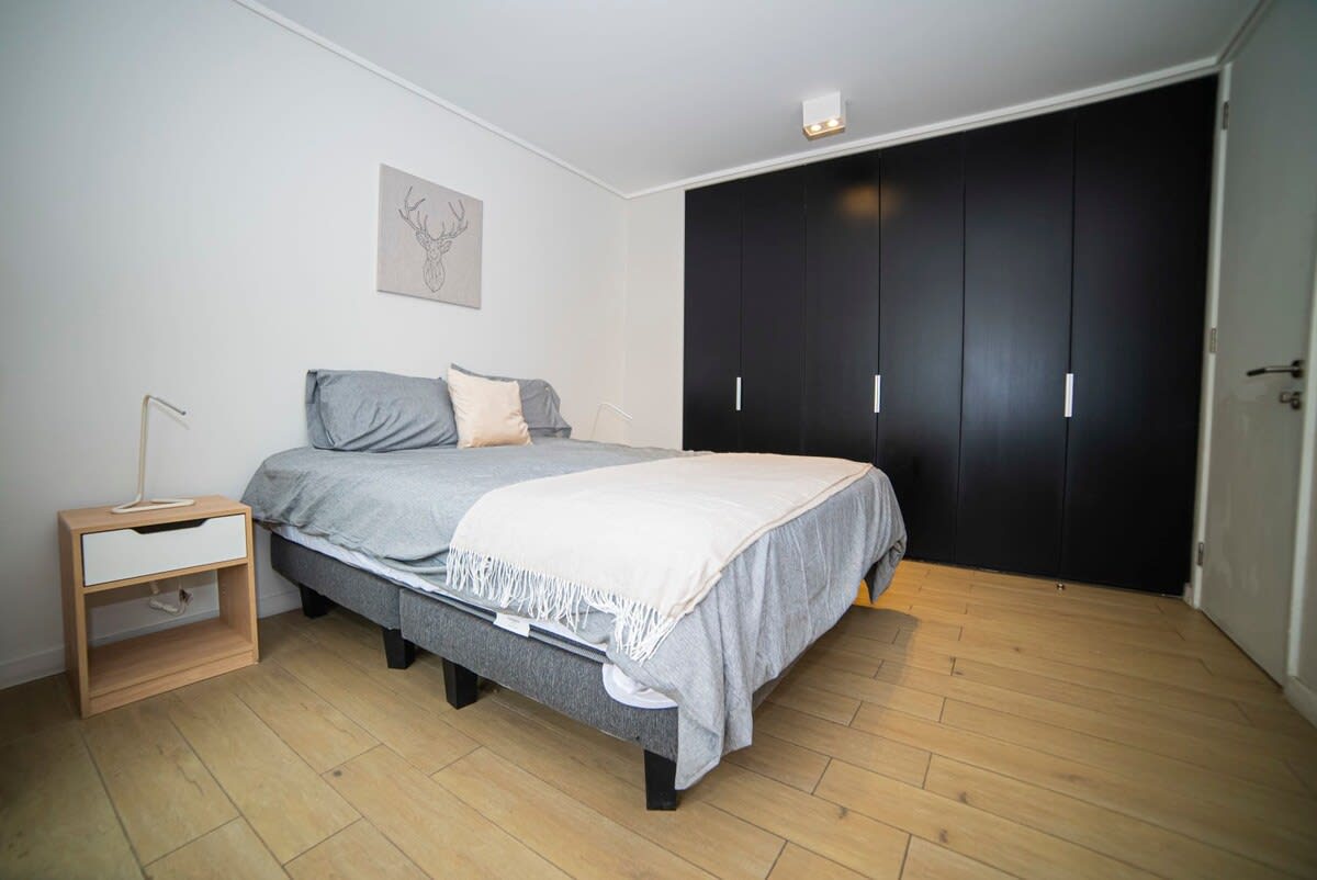 Cozy and modern bedroom with ample storage and stylish decor, perfect for a relaxing stay.